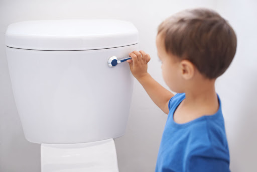 Little kid flushing the toilet.