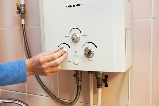 A hand adjusting a tankless water heater setting.