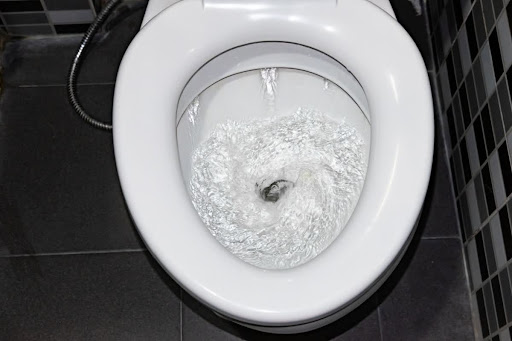 A toilet in the middle of being flushed.