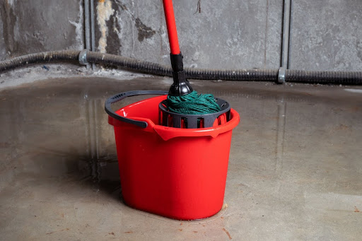 Mop in bucket trying to clean a flooded basement